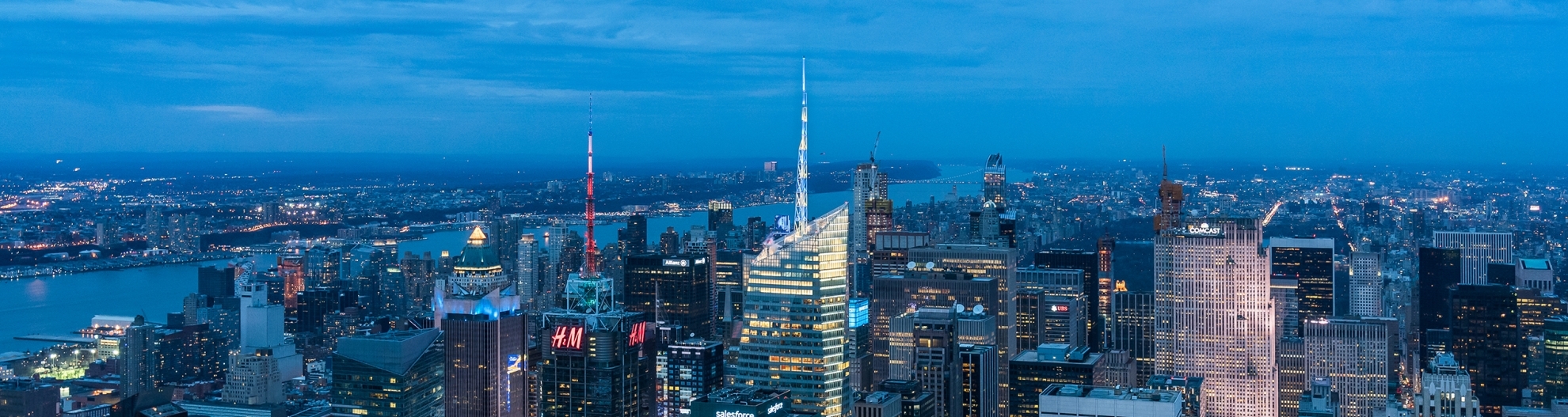 his high angle view looks north toward the high rise towers in midtown Manhattan with Central Park and the Hudson River in the background.